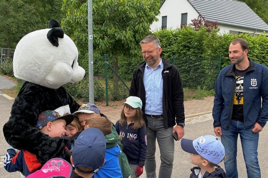Heißgeliebter Panda: Kinder aus der Kita Böhrigen bestürmen das WWF-Wappentier. Edeka-Betriebsleiter Stephan Kleyer (M.) und Ortsvorsteher Philipp Resch freuen sich über die gelungene Aktion.