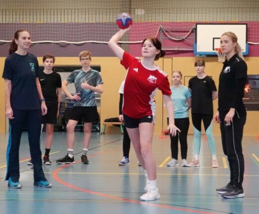 Sportlehrerin Jana Preussler (links) und Bundesliga-Spielerin Lena Hausherr (rechts) stehen Nachwuchs-Handballerinnen und -handballern des Zwickauer Käthe-Kollwitz-Gymnasiums zur Seite. 