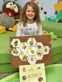 Warum eine Genossenschaft ihre Mieter mit Honig versorgt - Die fünfjährige Emily zeigt das Dankeschön-Plakat der Kinder.