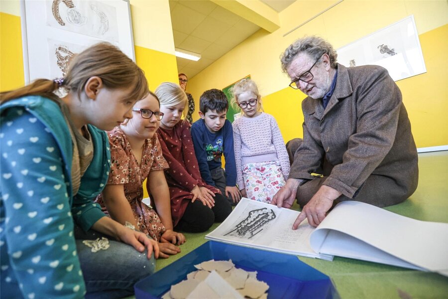 Warum sich eine Chemnitzer Brennpunktschule der Kunst verschrieben hat - 20 Bilder aus seiner Serie „Ecce Homo“ stellt Michael Morgner derzeit in der Albert-Einstein-Grundschule aus. Die Kinder lauschen gespannt den Erklärungen des 82-Jährigen.