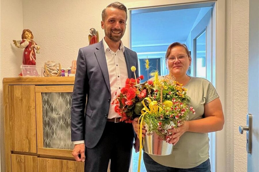 Warum sich eine Frau aus Bochum in Frankenberg heimisch fühlt - WGF-Geschäftsführer Enrico Grille gratuliert Ina Monderewitz zum Einzug. Sie ist die erste Mieterin im sanierten Block Einsteinstraße 39/41.