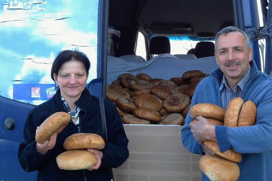 Achim Döbrich und eine Mitarbeiterin verteilen Brot und Spenden vom Nehemia-Freundeskreis an die Bewohner an der Frontlinie.