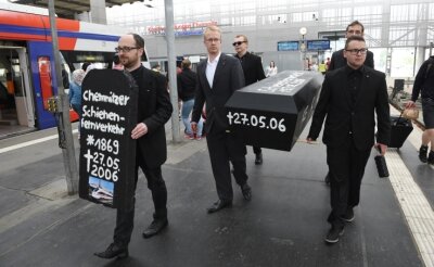 Was der Sarg im Bahnhof soll - Totengräberstimmung am Hauptbahnhof: Mitglieder der Partei Die Linke (vorn links Landtagsabgeordneter Nico Brünler), erinnern an den letzten Tag, an dem in Chemnitz ein Fernzug fuhr.