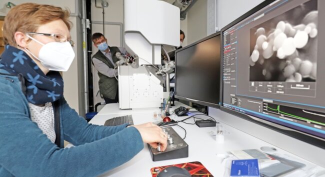 Nora Brachhold, wissenschaftliche Mitarbeiterin im Freiberger Neubau, und Ralf Haak von der Firma Tescan probieren die Funktionen eines Hochleistungs-mikroskopes aus. 