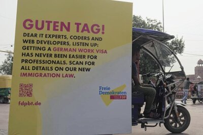 Was ist so "historisch" am Fachkräfteeinwanderungsgesetz, Herr Herbst? - Fachkräftewerbung in Indien: Eine Rikscha fährt mit einem FDP-Plakat durch Neu-Delhi. 