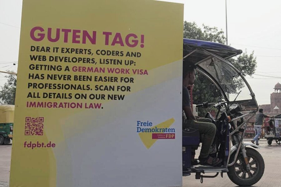 Was ist so "historisch" am Fachkräfteeinwanderungsgesetz, Herr Herbst? - Fachkräftewerbung in Indien: Eine Rikscha fährt mit einem FDP-Plakat durch Neu-Delhi. 