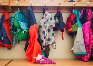 Was machen die Corona-Lockdowns mit Kindern? - Symbolbild: Jacken und Rucksäcke hängen in der Garderobe einer Kita. Ab Dienstag dürfen berufstätige Eltern in Sachsen ihre Kinder wieder zur Kita bringen. 