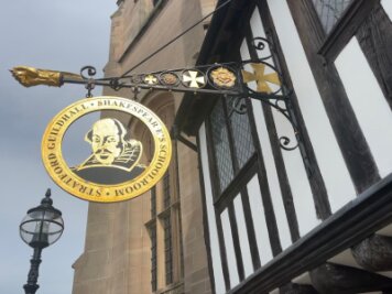 Was man von Shakespeare heute noch lernen kann - Ein Schild an einem historischen Gebäude (Guildhall) in Stratford-upon-Avon erinnert an William Shakespeare.