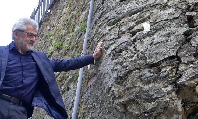 Bürgermeister Bernd Pohlers wirft einen Blick auf die Schäden an der Stützmauer am Torberg. 