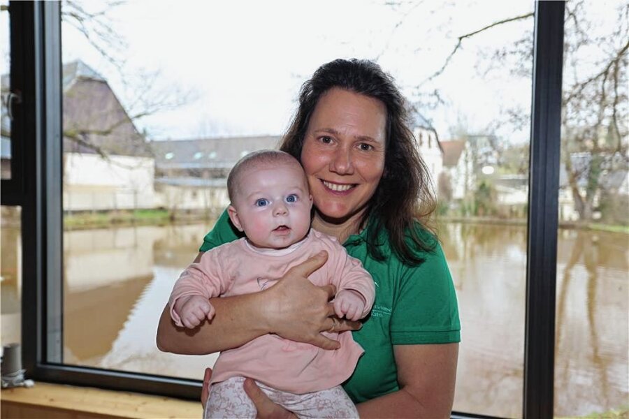 Was sich beim Kinderkriegen im Landkreis Zwickau in 25 Jahren verändert hat - Eine Hebamme erzählt - Hebamme Katrin Schwind mit Baby Maja aus Waschleithe im Anbau ihrer Praxis, der direkt an einen Teich grenzt. 