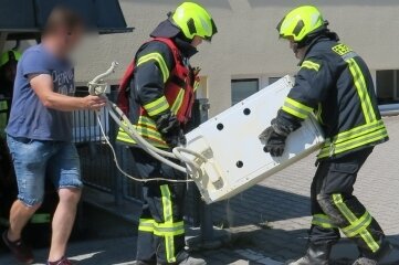 Waschmaschine gerät in Brand - Feuerwehrleute trugen die Waschmaschine aus dem Ärztehaus Heide ins Freie. 