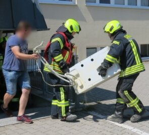 Waschmaschine gerät in Brand - Feuerwehrleute trugen die Waschmaschine aus dem Ärztehaus Heide ins Freie. 