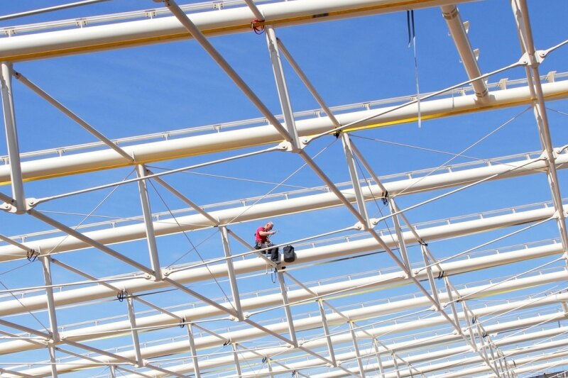 Webalu-Eröffnung in Werdau verschiebt sich auf unbestimmte Zeit - Einsam und verlassen sitzt ein Bauarbeiter auf der neuen Dachkonstruktion im Webalu. Er genießt dort weder die Aussicht noch die Mittagssonne, sondern zieht Schrauben fest.
