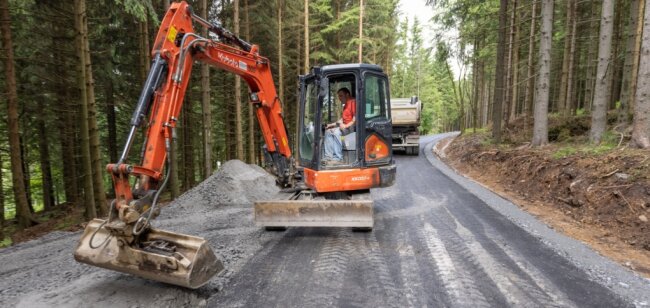Ein Abschnitt des Bärenfangwegs nahe Oberwiesenthal hat in den vergangenen Tagen eine neue Asphaltdecke erhalten. Das Foto zeigt Steffen Schreier bei Anpassungsarbeiten zur Anbindung eines anderen Waldwegs. 