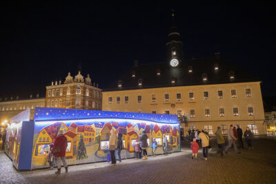 Weihnachtsbaum, Pyramide und Wichtelwerkstatt leuchten auf dem Annaberger Markt - Erste Besucher vor der Wichtelwerkstatt am Freitag.