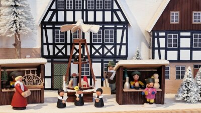 Weihnachtsschau im Schloss: Museum trifft Häuslemacher - Häuschen und Weihnachtsmarktbuden dieser Dorfszene in einem Schwibbogen stammen aus der Firma Naumann Volkskunst in Rechenberg-Bienenmühle, die Figuren von anderen Herstellern.