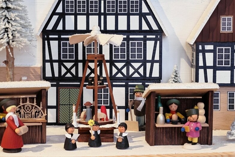Weihnachtsschau im Schloss: Museum trifft Häuslemacher - Häuschen und Weihnachtsmarktbuden dieser Dorfszene in einem Schwibbogen stammen aus der Firma Naumann Volkskunst in Rechenberg-Bienenmühle, die Figuren von anderen Herstellern.