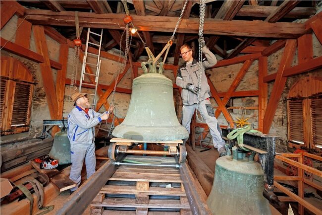 Weil der Absturz drohte: Fast 500 Jahre alte Glocke sieht erstmals Tageslicht - Christian (links) und Daniel Beck hieven die älteste der drei Glocken auf den Schienenschlitten.