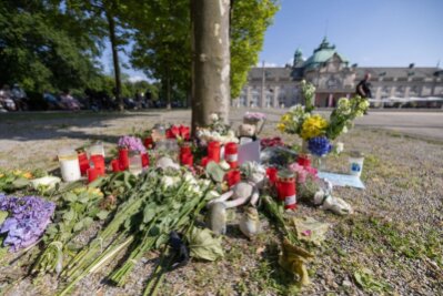 Weitere Ermittlungen nach Angriff in Bad Oeynhausen - Blumen, Kerzen und handgeschriebene Trauerbekundungen an einem Baum im Kurpark Bad Oeynhausen.