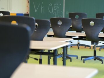            In einem leeren Klassenzimmer sind die Stühle auf die Schulbänke gestellt.