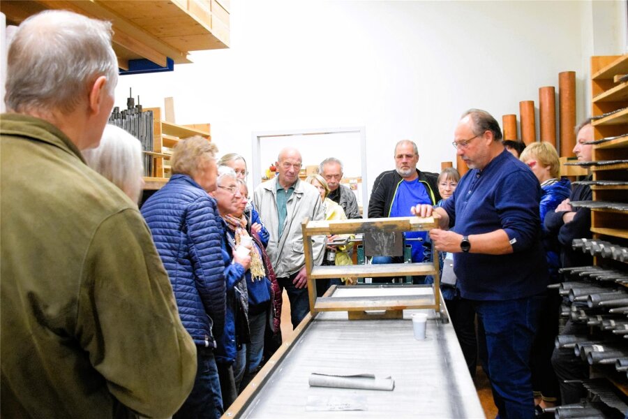 Welche Hürden ein Orgelbaumeister überwinden musste, bevor er in Limbach Orgeln bauen konnte - Thomas Wolf (rechts) zeigt den Besuchern, wie die Zinnplatten für die Metallpfeifen entstehen.