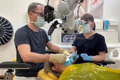 Welche Wurzelbehandlung bezahlt die Krankenkasse? - Der Wurzelspezialist Dr. Mario Schulze und Assistentin Nadine Kostmann aus Dresden nutzen bei der Wurzelbehandlung ein Operationsmikroskop, um feinste Kanäle besser zu entdecken.