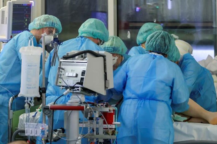 Alltag auf der Intensivstation der Leipziger Uniklinik: Ein Facharzt und fünf Intensivpfleger drehen einen Covid-19-Patienten in die Bauchlage. Damit die Kapazitäten reichen, wurden planbare OPs deutlich verringert. 