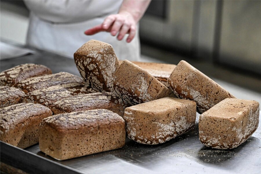 Weniger Bäckereien in Sachsen: So wandelt sich das Handwerk - Vollkornbrote werden nach dem Backen im Ofen aus ihren Formen genommen. Die Anzahl der Bäckereien in Sachsen ist in den letzten Jahren gesunken.