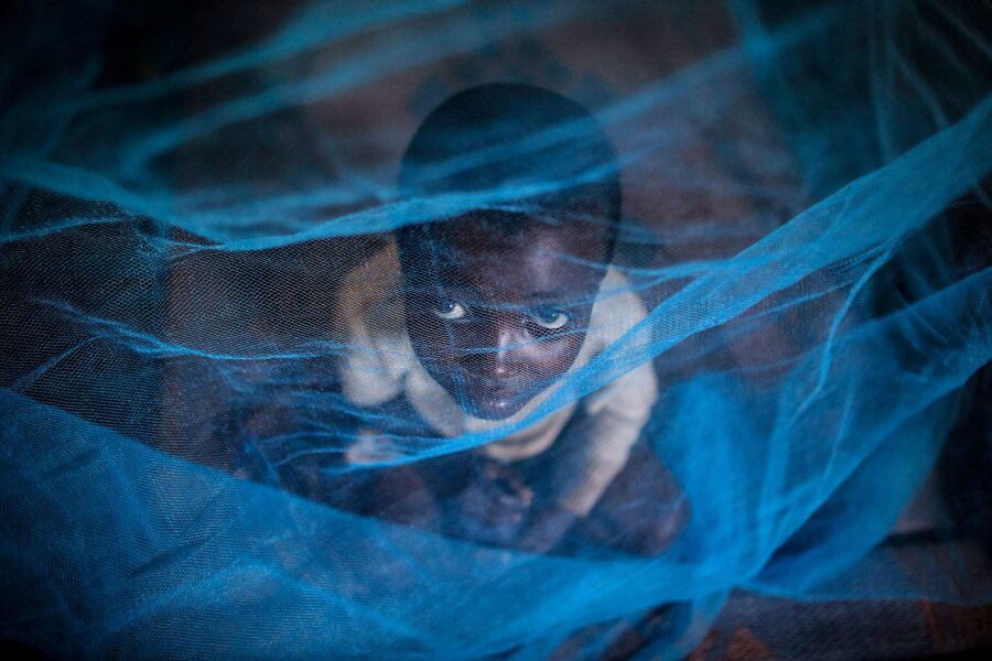 Weniger Malaria in Afrika? - Ein Flüchtlingskind aus Burundi sitzt in Gashora, Ruanda, unter einem Moskitonetz: Der Malaria-Erreger wird durch Anopheles-Stechmücken übertragen.