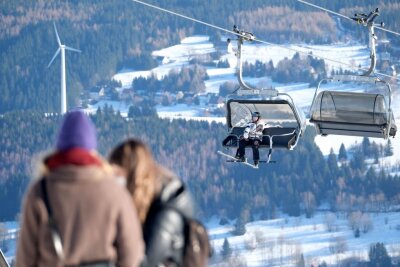 Weniger Schnee: Sachsen sucht Alternativen zum Skitourismus - Ein Wintersportler sitzt in der Gondel eines Liftes auf dem Fichtelberg.