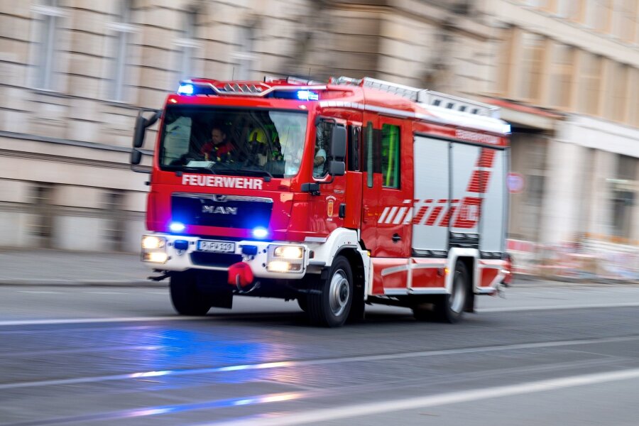 Weniger Unwetterschäden als befürchtet in Sachsen - Ein Feuerwehrfahrzeug ist mit Blaulicht auf Einsatzfahrt.