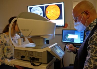 Wenn Augenärzte fehlen: Optiker hat mit Vorsorge-Screening Erfolg - Optikermeister Benedikt Lommer beim telemedizinischen Augen-Screening. Die hochaufgelösten Aufnahmen des ganzen Auges und speziell der Netzhaut werden dabei auch direkt auf einem Bildschirm abgebildet. 