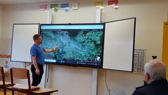 Michael Merkel, IT-Betreuer der Grundschule Weißenborn, zeigt den Räten, wie Whiteboard und Aktivtafel funktionieren. Kurzerhand schwebte er mit den Händen über die digitale Landkarte von Google Earth. 