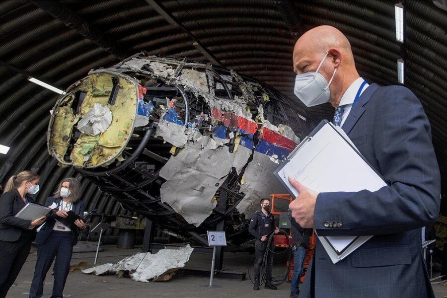 Wer schoss MH-17 über der Ukraine ab? - Der vorsitzende Richter Hendrik Steenhuis (r) und andere Prozessrichter und Anwälte betrachten das rekonstruierte Wrack von Malaysia Airlines Flug MH17, auf dem Militärflugplatz Gilze-Rijen. 