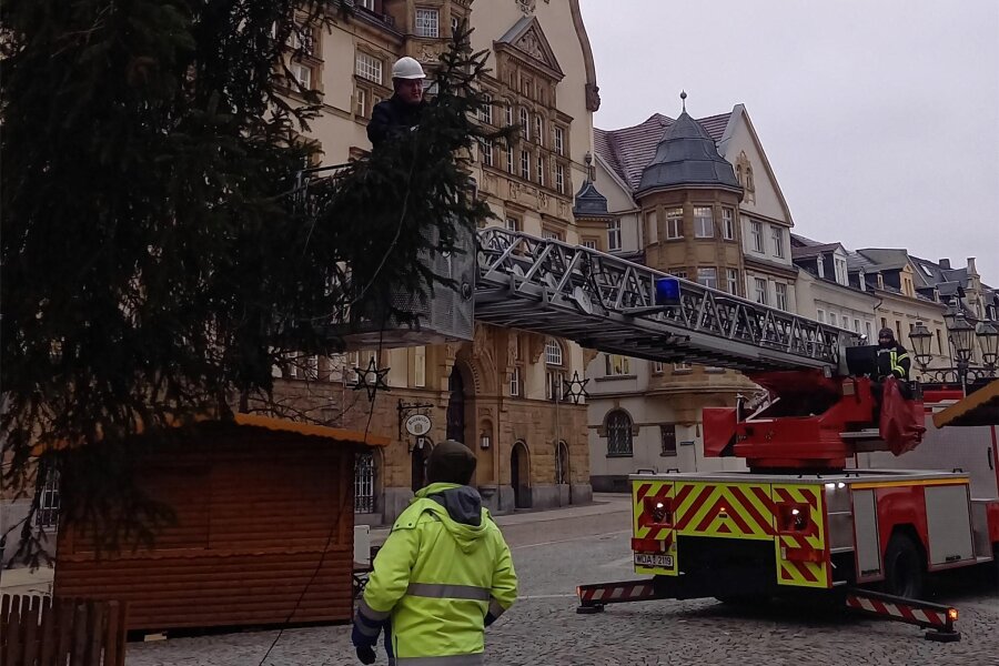 Werdau räumt den Weihnachtsschmuck weg – Markt bleibt gesperrt - Mitarbeiter der Stadtwerke haben mit Unterstützung der Feuerwehr die Beleuchtung vom Weihnachtsbaum abmontiert.