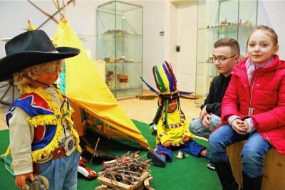 Werdauer Museum zeigt Kinderspielwelten - Die siebenjährige Ella und ihre großer Bruder Paul aus Werdau sitzen am Lagerfeuer vor dem Indianertipi. 