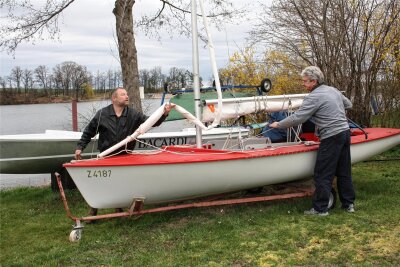 Werdauer Segler machen die Boote startklar - Ralf Reuter (links) und Uwe Rehm holen ein Segelboot der Klasse Ixylon aus dem Winterschlaf.