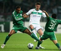 Werder Bremens Jurica Vranjes (m.) im Duell mit zwei Spielern der Griechen aus Athen