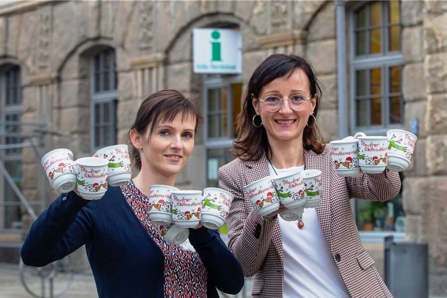 Weshalb die Stadt Plauen Glühweintassen aus deutscher Produktion ablehnt - Kathleen Dentler und Anja Linke mit der Glühweintasse 2021. Die Gefäße sind alljährlich ein begehrtes Sammlerobjekt. 