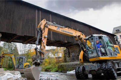 Wie die Hennersdorfer Holzbrücke vor Überlastung geschützt werden soll - Die Arbeiten am Unterbau der historischen Holzbrücke in Hennersdorf haben begonnen. Dabei werden voraussichtlich bis Sommer kommenden Jahres die Widerlager und der Mittelpfeiler saniert. 