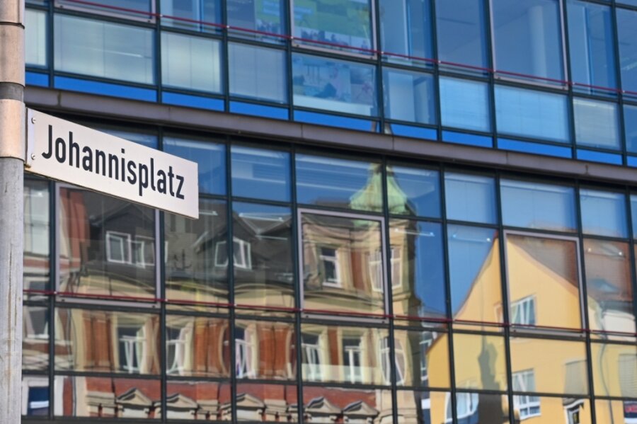 Wie die Innenstadt vom Limbach-Oberfrohna lebendiger werden soll - Häuser am Johannisplatz in Limbach-Oberfrohna spiegeln sich in einer Glasfassade. Die Stadt will ihr Zentrum mit verschiedenen Ideen auch mit Blick auf das Kulturhauptstadtjahr 2025 in Chemnitz weiter aufwerten. 