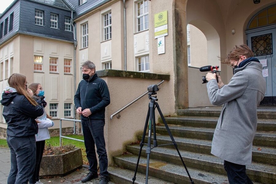 Wie die Oederaner ihre Oberschule in Szene setzen - Für den Filmdreh über die Oberschule Oederan begrüßt Schulleiter Frank Hunger am Eingang zwei Schülerinnen. Max Porstmann, der die benachbarte Grundschule besuchte, hat die Szene schnell im Kasten. 