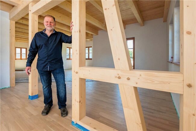 Wie ein Wolkensteiner das Fachwerkhaus neu erfindet - Geschäftsführer Heiko Schulz in einem neu errichteten Haus, in dem sowohl Fachwerk als auch die Holzbalkendecke sichtbar sind. 