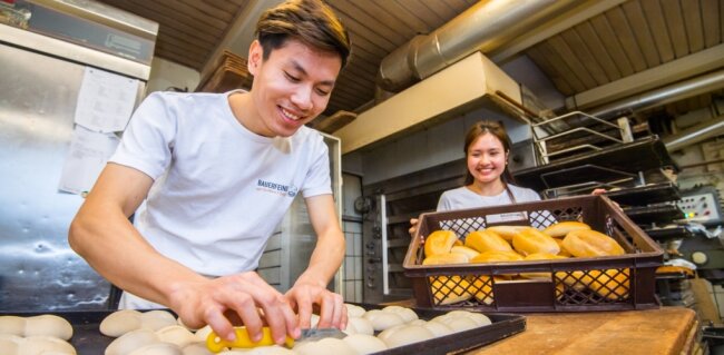 Wie eine Bäckerei das Azubi-Problem löst - In der Bäckerei Bauerfeind in Hohndorf werden zwei Vietnamesen - Duc Hoang Dinh (links) und Hieu Minh Pham (rechts) - ausgebildet. Ihnen macht ihr Job große Freude. Ihre Ausbildung dauert noch zwei Jahre.