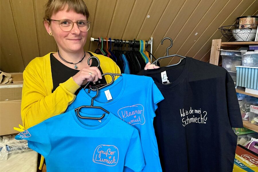Wie eine Erzgebirgerin Mundart-Begriffe in einer winzigen Werkstatt rettet - Katja Stübner zeigt einige ihrer selbst gefertigten T-Shirts.