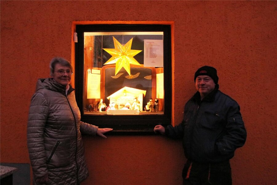 Wie eine Idee aus Coronazeiten in Rothenkirchen heute für schöne Momente sorgt: Die Weihnachtsgeschichte im Fenster - Sigrid Leibiger und Andreas Seyfert vor dem Fensterbild Nummer 9 Am Bärenplatz.