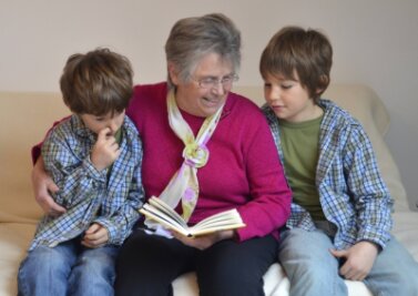 Wie eine richtige Oma - So unterstützen Familienpaten Eltern und Kinder - Kindern eine Geschichte vorzulesen, wie hier im Symbolbild die ältere Dame diesen Zwillingen - auch das gehört zu den Aufgaben eines Familienpaten. 