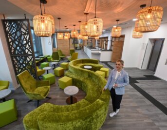 Wie es im neuen Chemnitzer Hotel Super 8 aussieht - Die Lobby: Hotelmanagerin Grit Vinzens steht zwischen dem in Grün gehaltenen Sofa, Hockern und Sesseln. Die Farbe ist die Firmenfarbe der HotelketteSuper 8. Im Hintergrund ist die Rezeption mit einem niedrigen Tisch, an dem Rollstuhlfahrer einchecken können, zu sehen. 