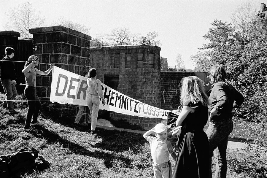 Wie geht es der Chemnitz heute? Künstler erinnern an Umweltprotest von 1990 - Im April 1990 spannten Umweltschützer dieses Banner am Neumühlenwehr über die Chemnitz. Daran soll ab Samstag im Rahmen der Ausstellung „Gegenwarten“ erinnert werden.