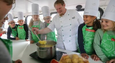 Wie Kartoffeln den Unterricht schmackhaft machen - In einem sogenannten Kochbus zeigt Koch Martin Schneider den Niederfrohnaer Schülern, wie vielfältig die Kartoffel zubereitet werden kann. Dabei wurden die Kinder selbst aktiv, schälten und schnitten die Knollen. 